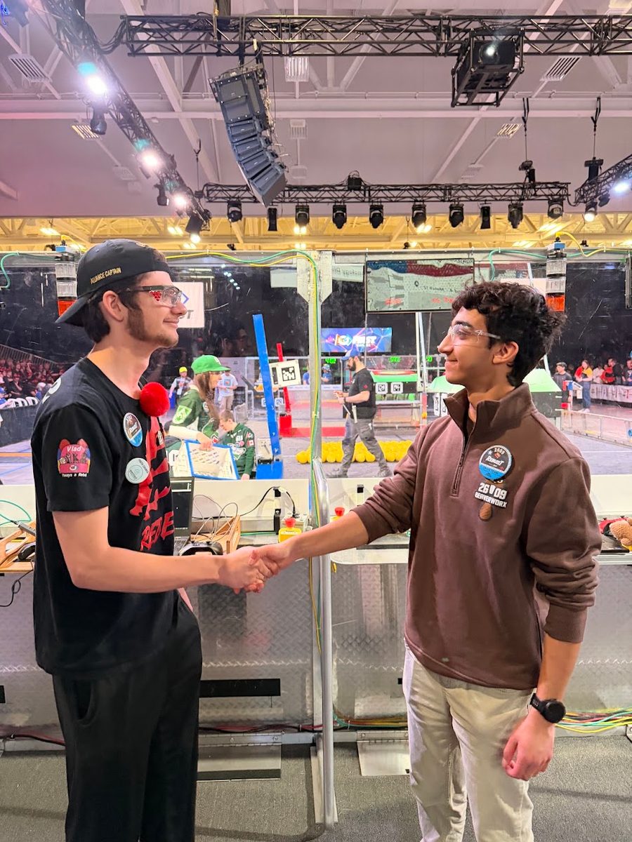 A Team 2609 Beaverworx student shaking hands with a member of another team at a FIRST Robotics Competition event