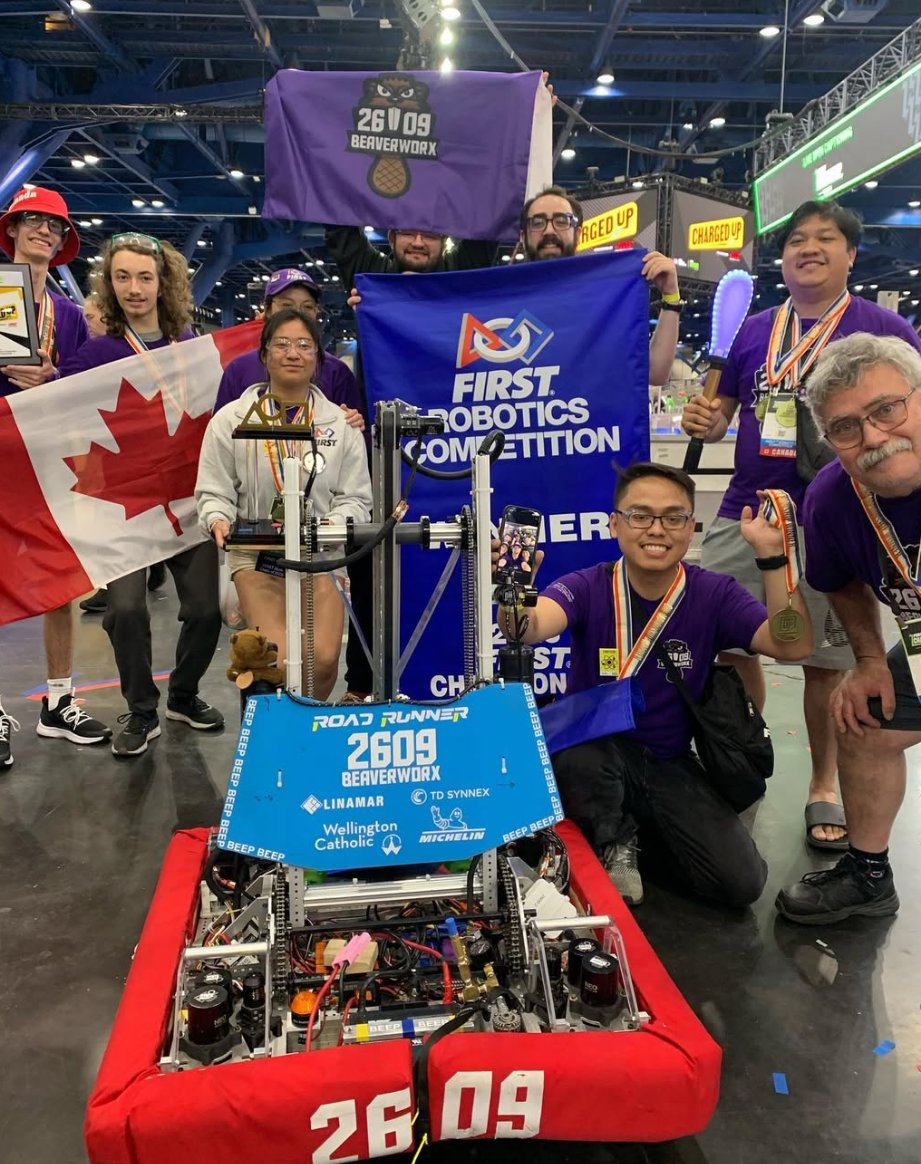 Team 2609 Beaverworx celebrating with The Road Runner and the FIRST Championship banner in Houston, Texas